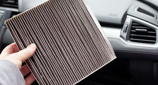 Hand holding Air Filter inside of car